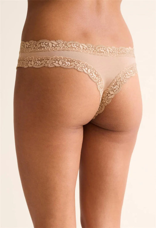 Beige lace-trimmed underwear on a plain background