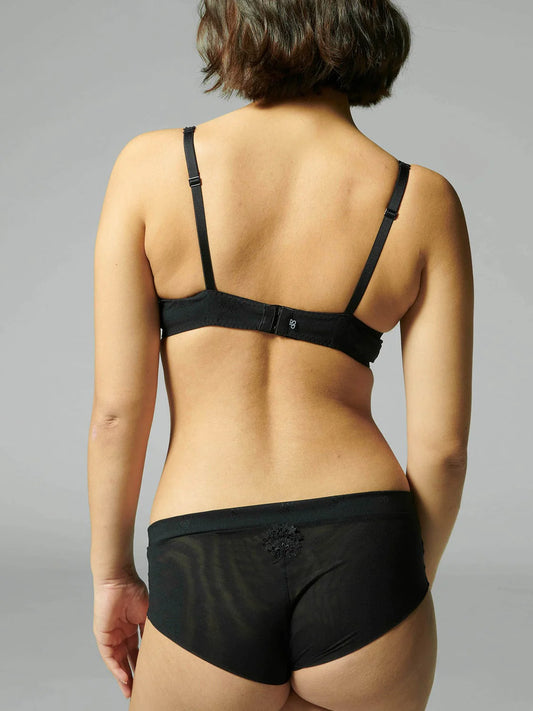 Person wearing a black bra and underwear set on a gray background