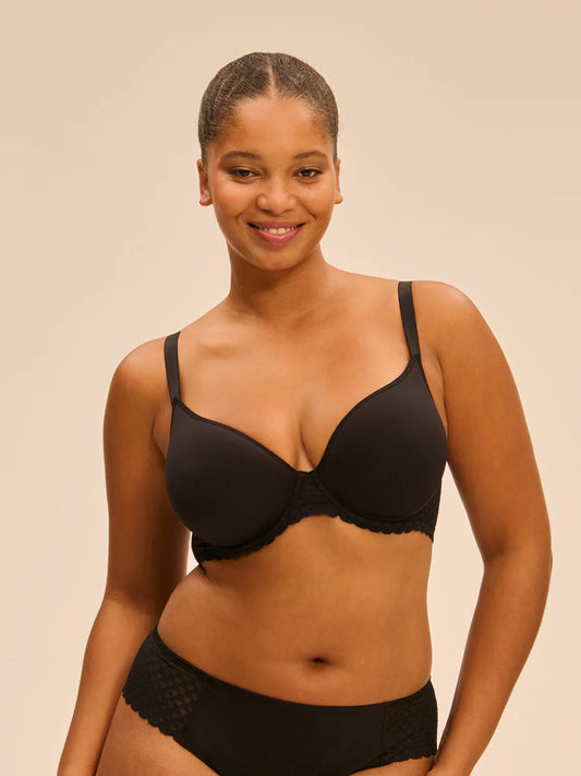 Woman wearing a black bra and underwear set on a beige background