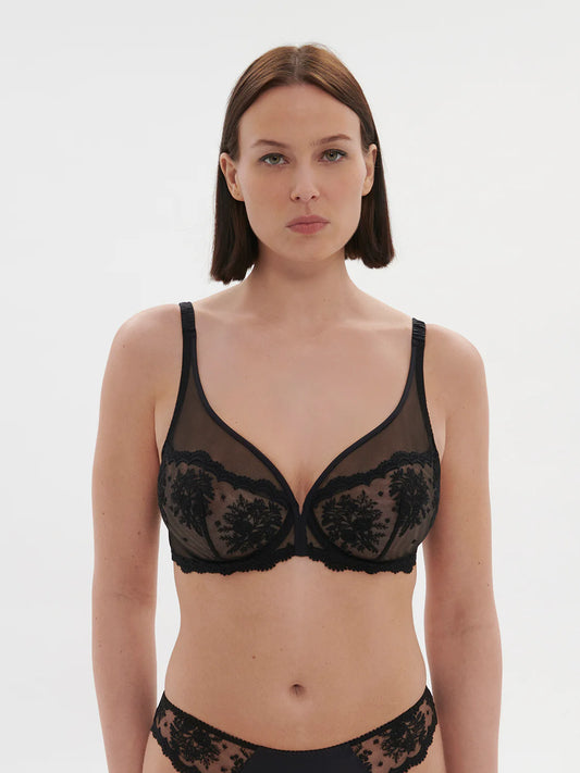 Woman wearing a black lace bra and panties set on a white background