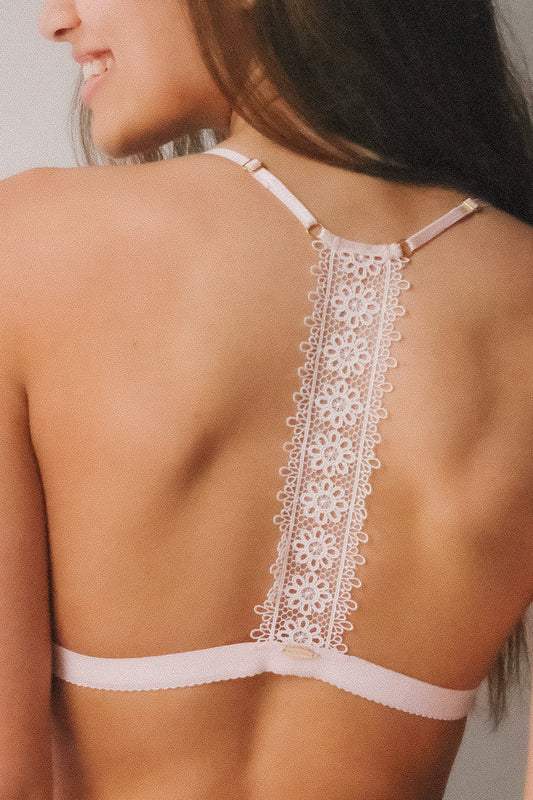 Close-up of a woman wearing a white lace bralette.