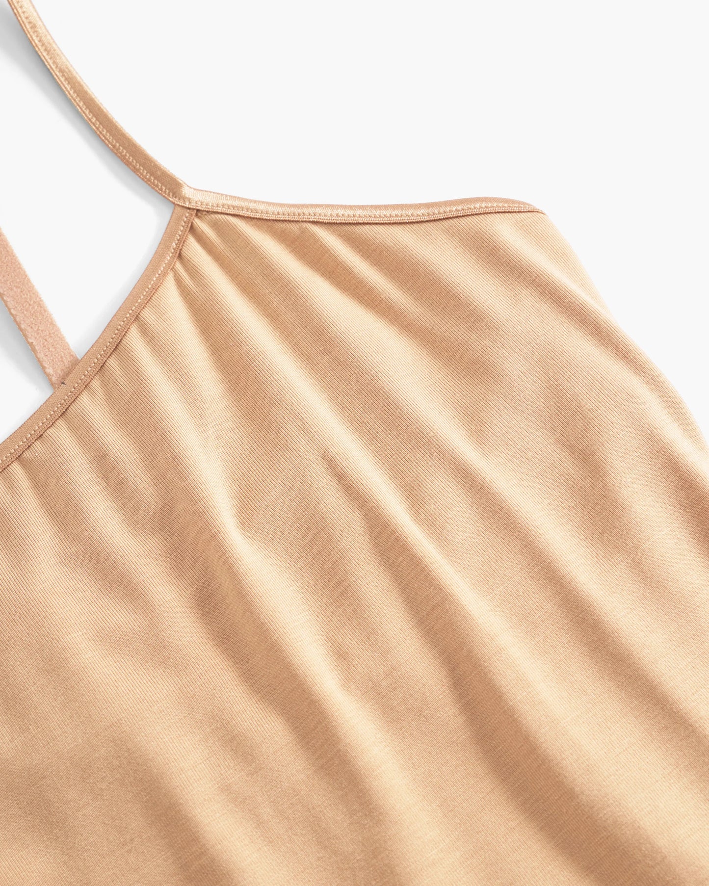 Close-up of a beige tank top with thin straps on a light gray background