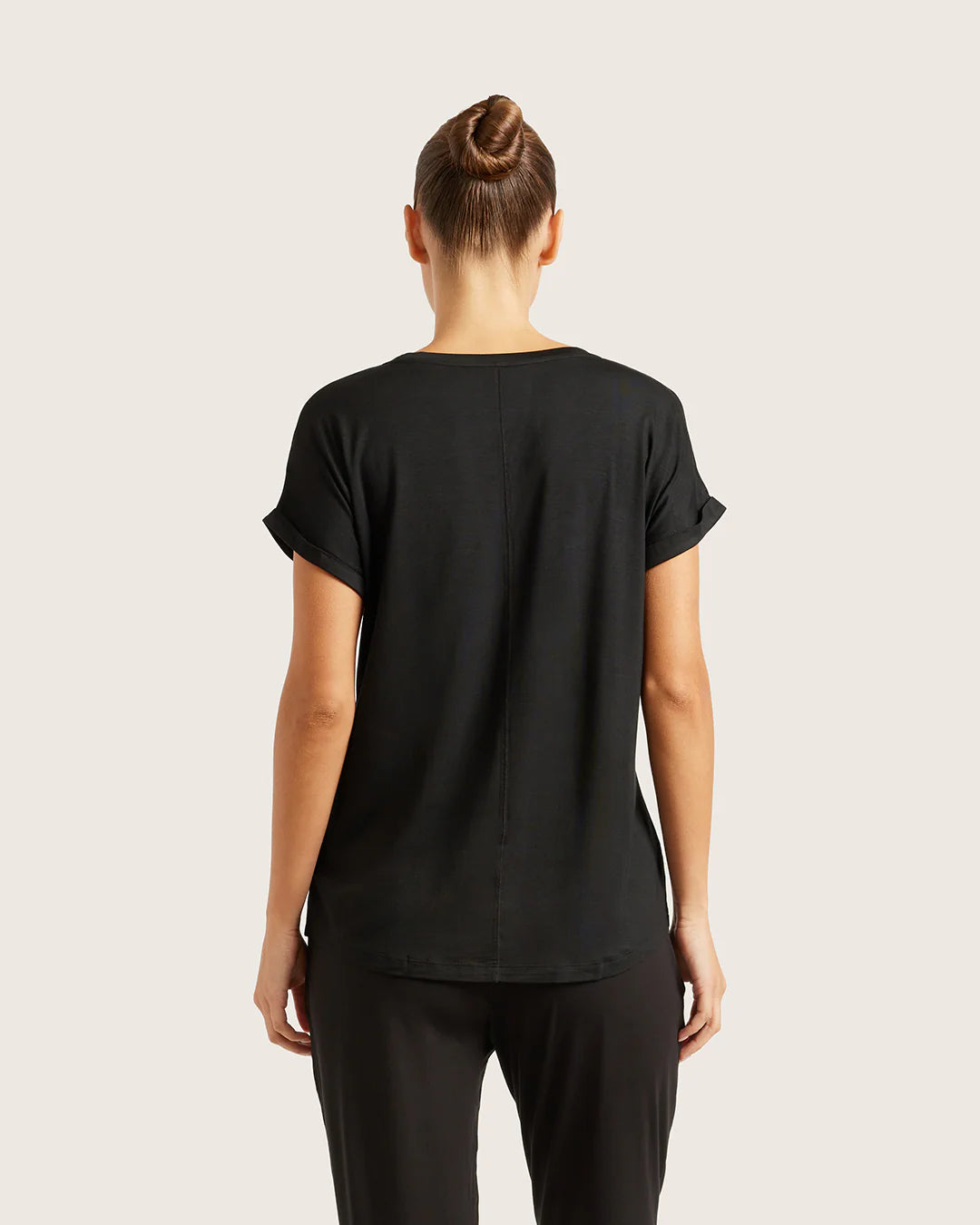 Person wearing a black t-shirt on a plain background