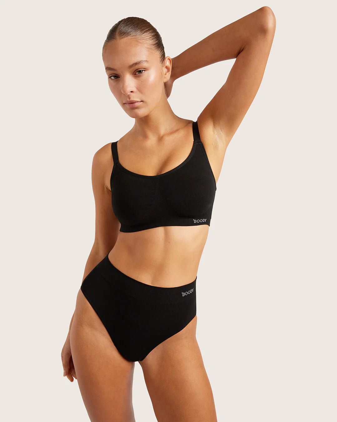 Woman wearing a black bikini with a plain background