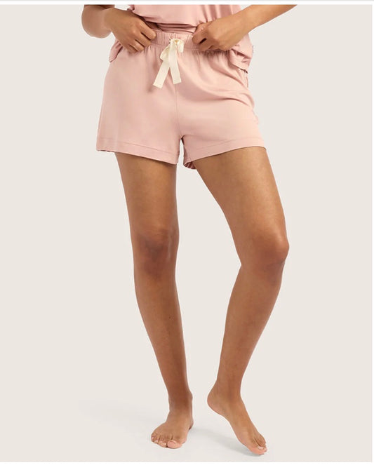 Person wearing pink shorts with a white background
