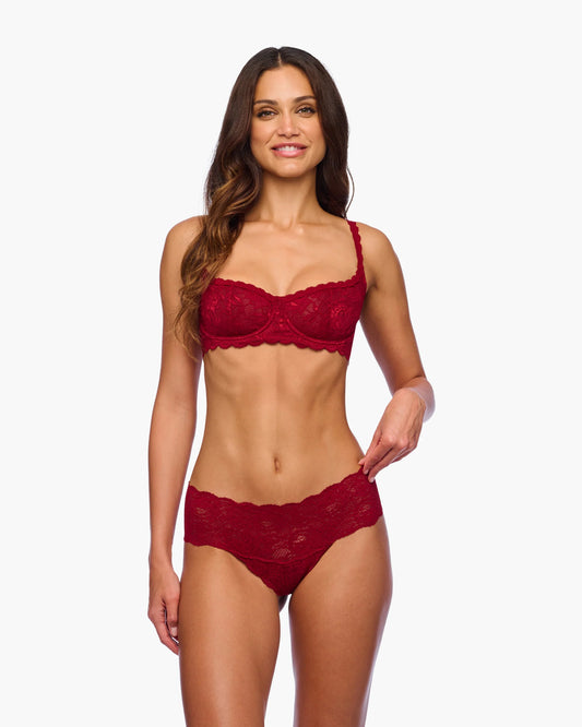 Woman wearing a red lace lingerie set on a white background