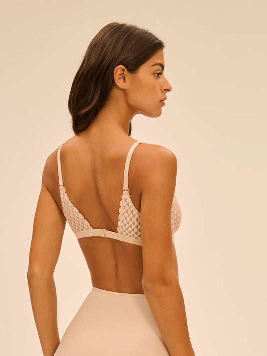 Woman wearing a beige bikini with textured design against a beige background