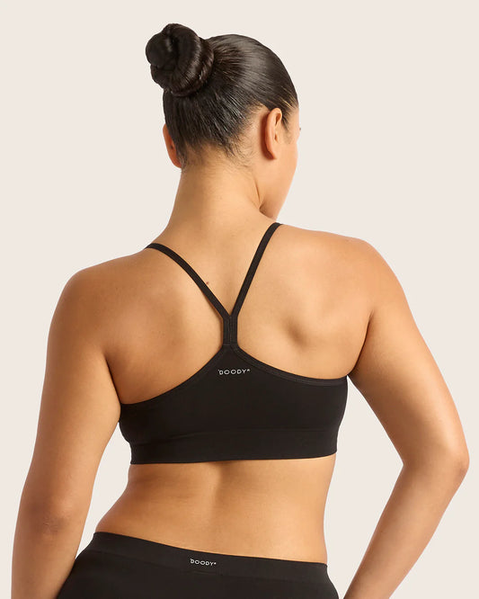 Person wearing a black sports bra with visible branding on a plain background