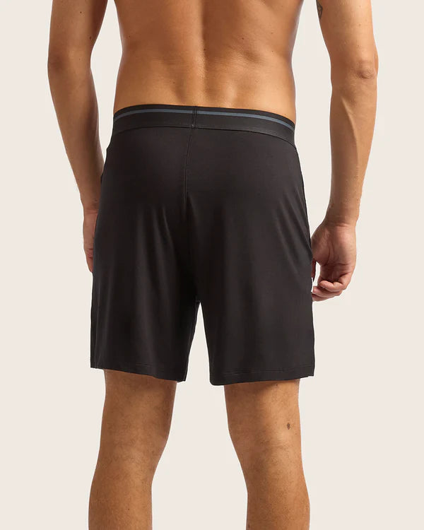 Person wearing black shorts on a plain background