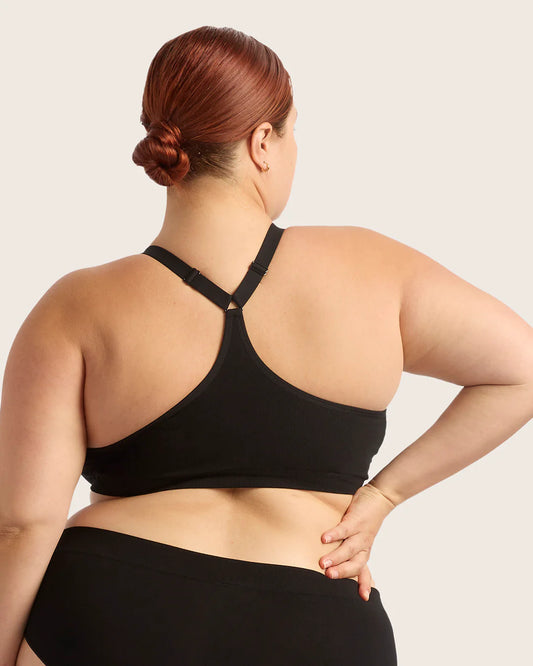 Person wearing a black sports bra and leggings on a plain background