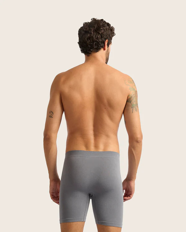 Man wearing gray boxer briefs against a plain background