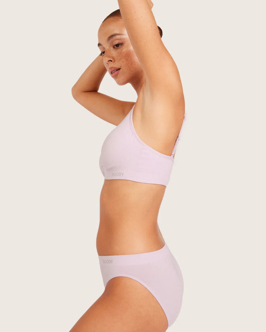 Woman wearing a light purple bikini set on a plain background