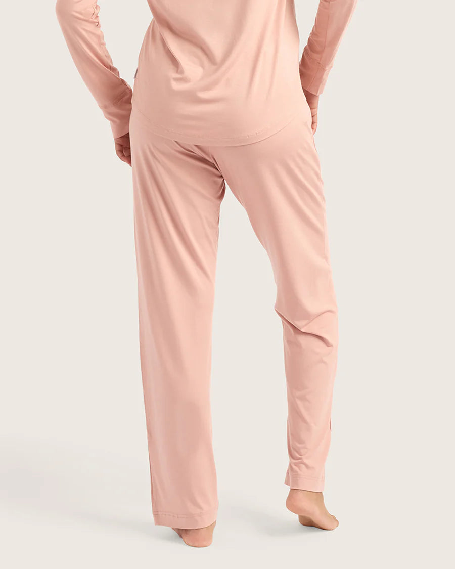 Person wearing a pink pajama set on a light gray background
