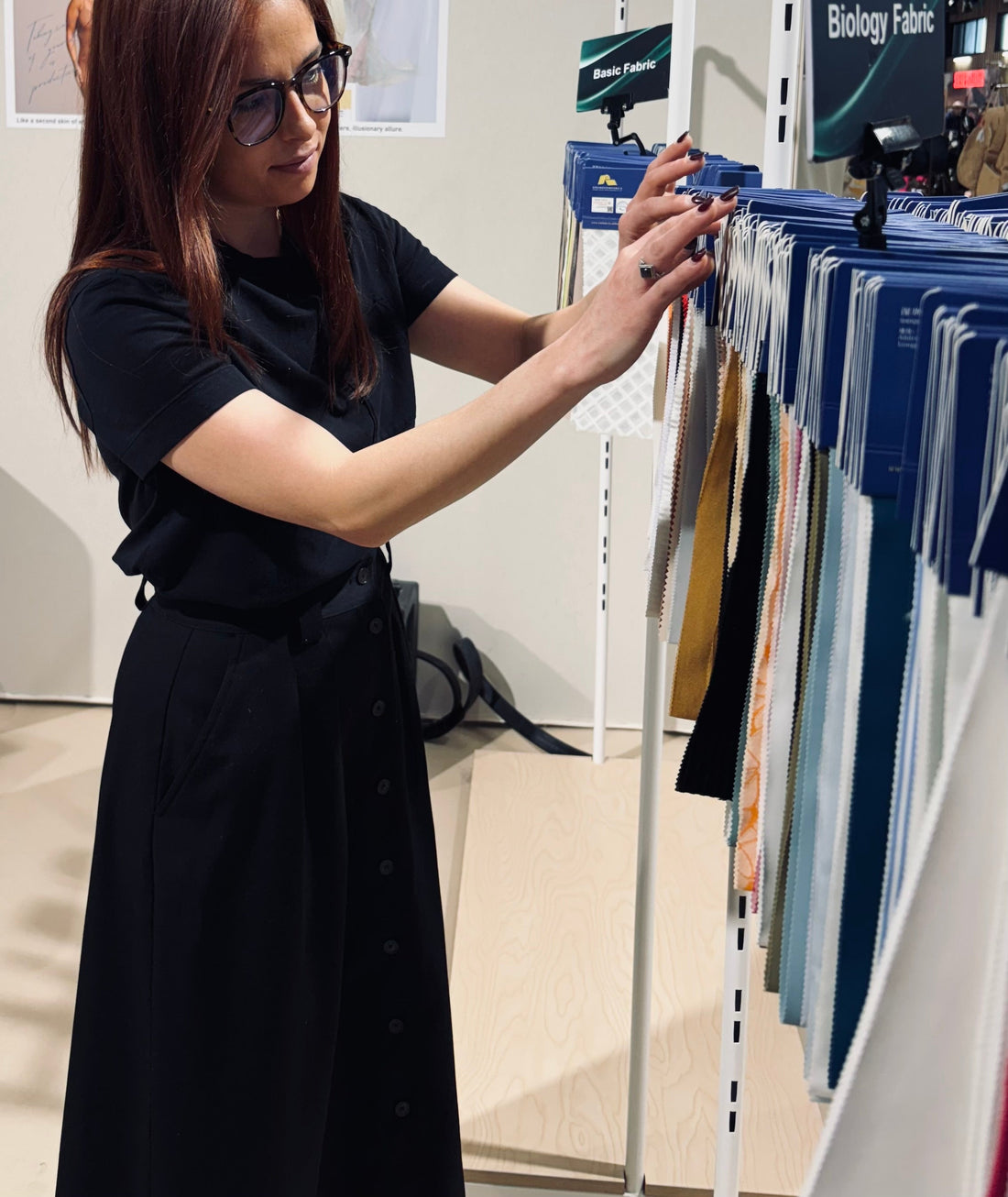 Kim examining fabric samples in a store.