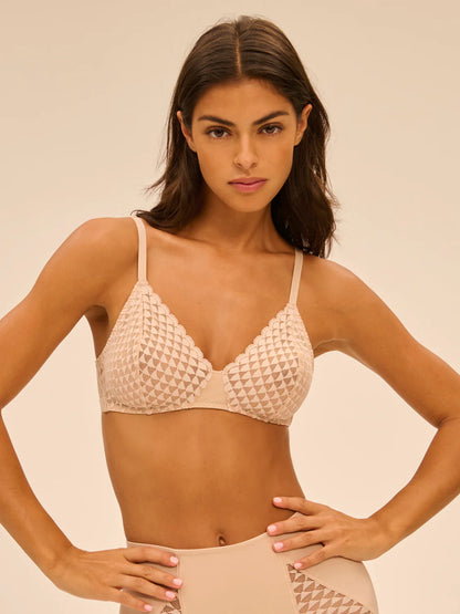 Woman wearing a beige textured bikini set against a beige background