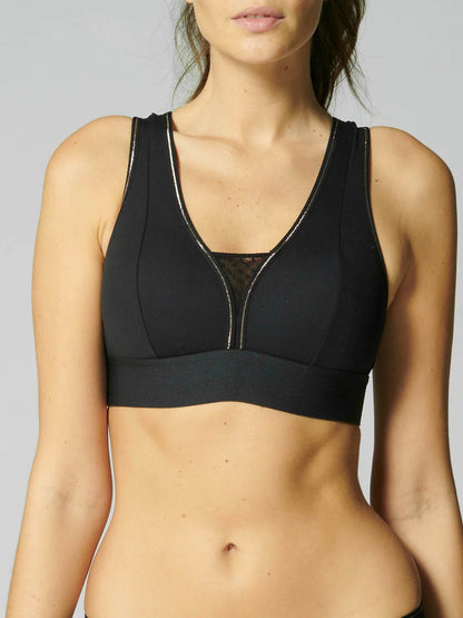 Black sports bra worn by a person on a gray background