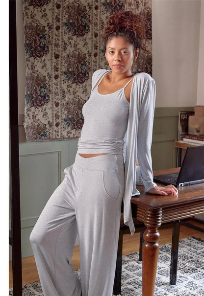 Woman in a white outfit sitting at a desk in a home office setting.