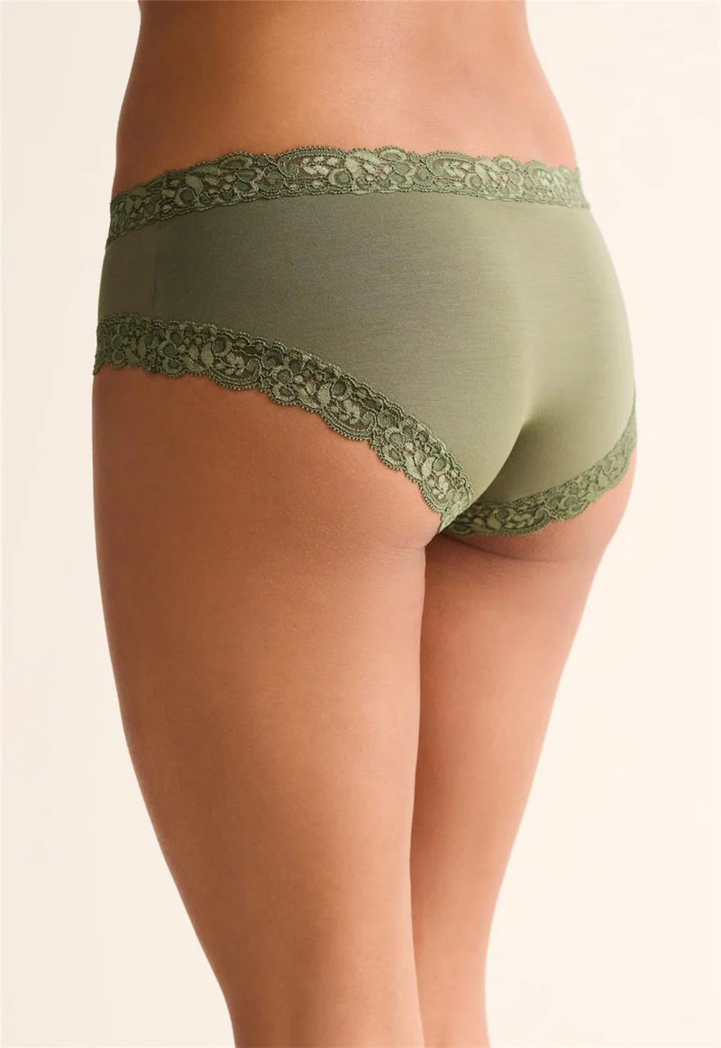Green lace-trimmed underwear on a beige background