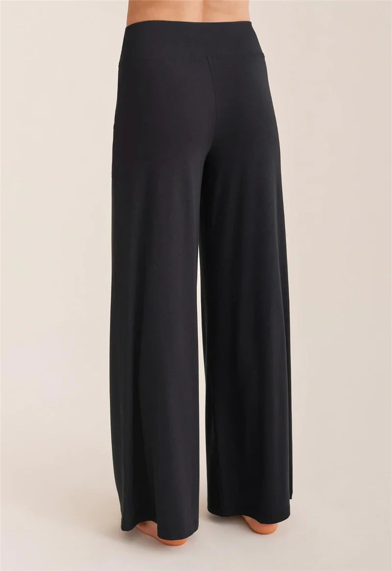 Black wide-leg pants on a beige background
