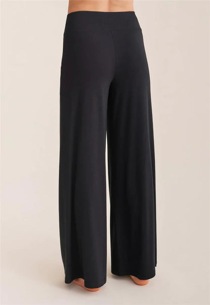 Black wide-leg pants on a beige background