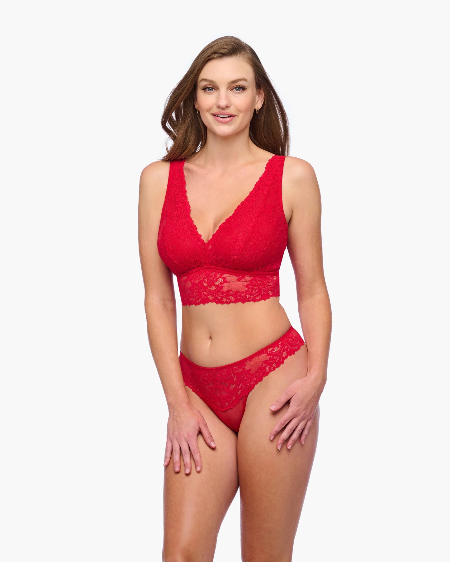 Woman wearing a red lace lingerie set on a white background