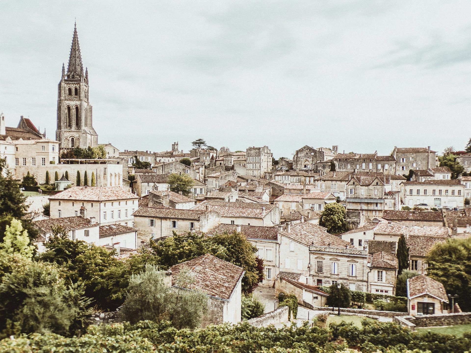 Townscape with a prominent church tower and residential buildings, surrounded by greenery.