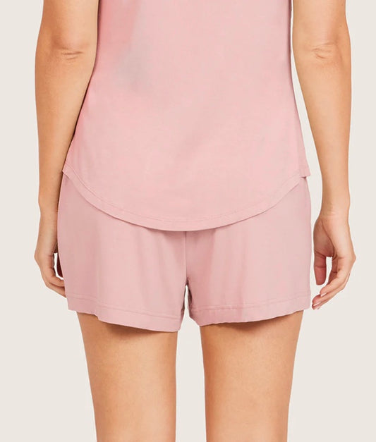 Person wearing a pink layered outfit on a plain background