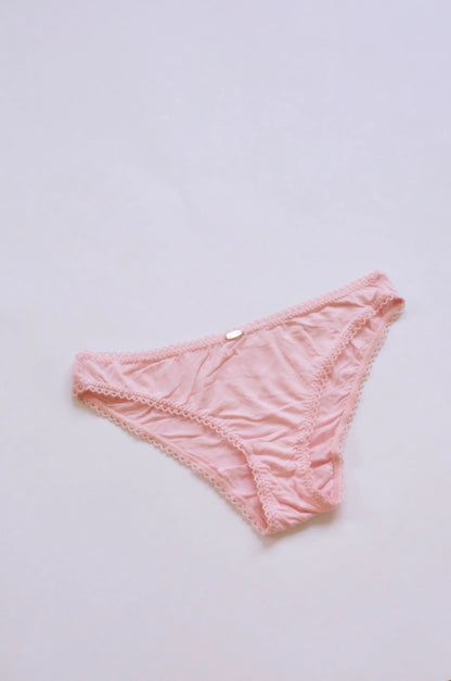Pink lace underwear on a light gray background