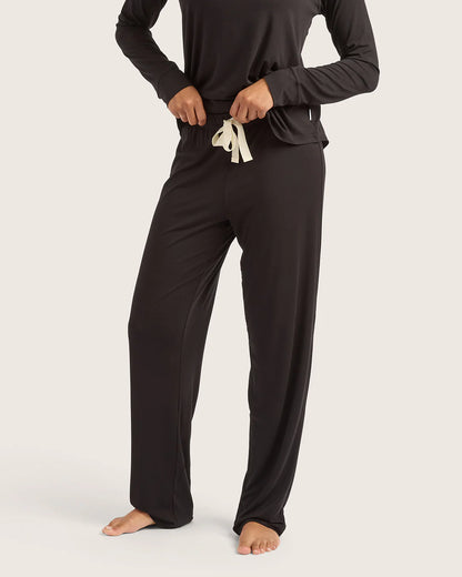 Person wearing black pajama set with white drawstring on a white background