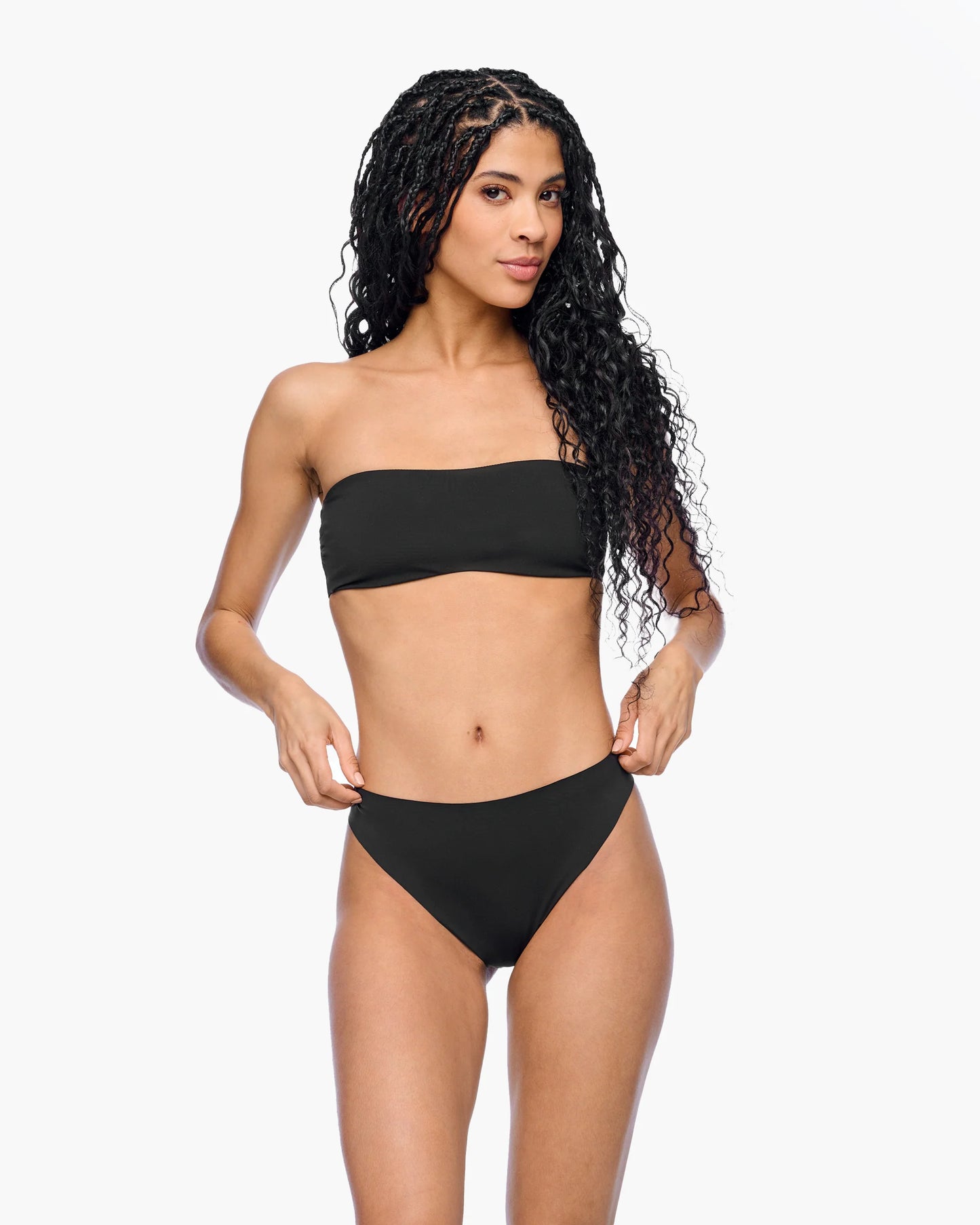 Woman wearing a black strapless bikini on a white background