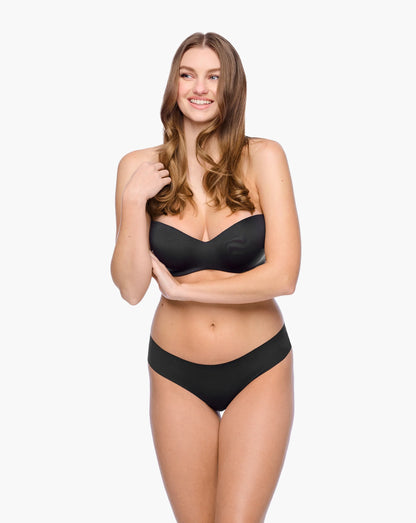 Woman wearing a black bra and panties set on a white background