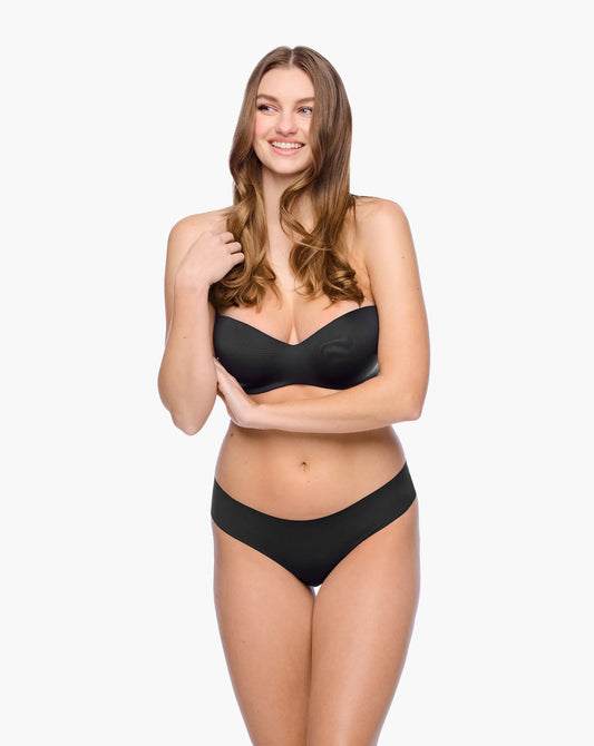 Woman wearing a black bra and panties set on a white background