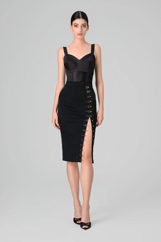 Black skirt with a front slit worn by a model on a gray background