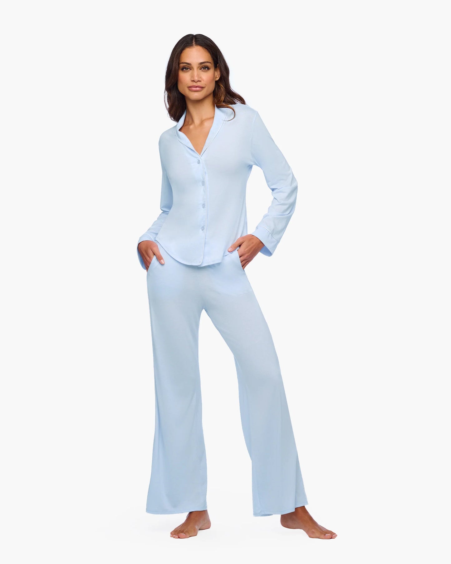 Woman wearing light blue pajama set on a white background