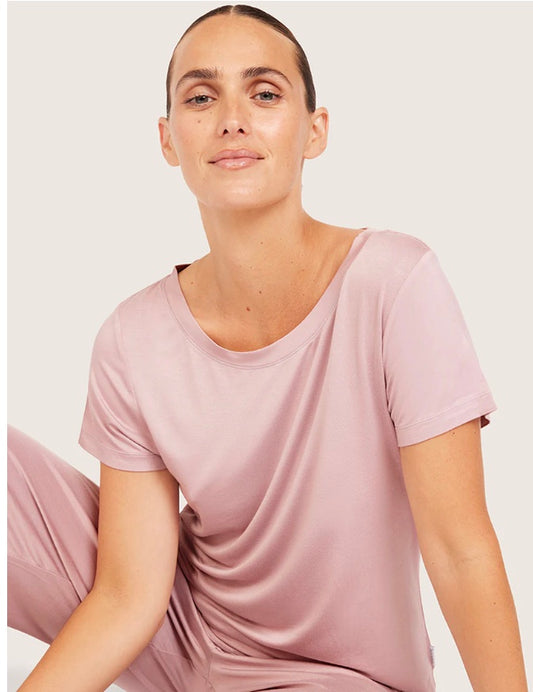 Person wearing a pink t-shirt and pants on a white background