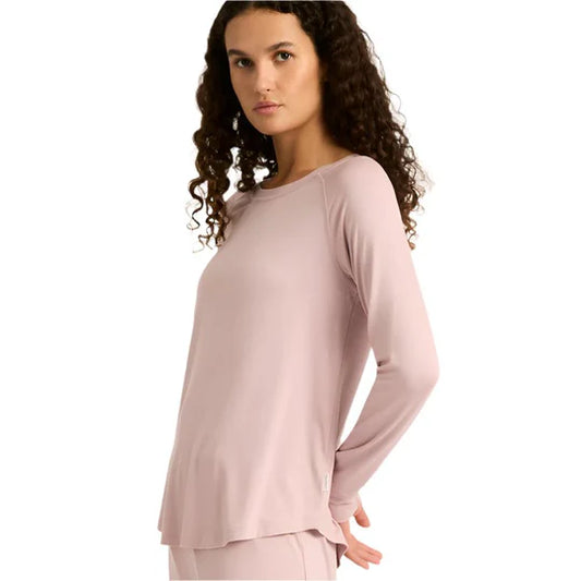 Woman wearing a light pink long-sleeve top on a white background
