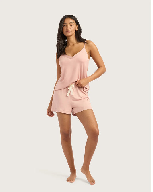 Woman wearing a pink pajama set on a white background