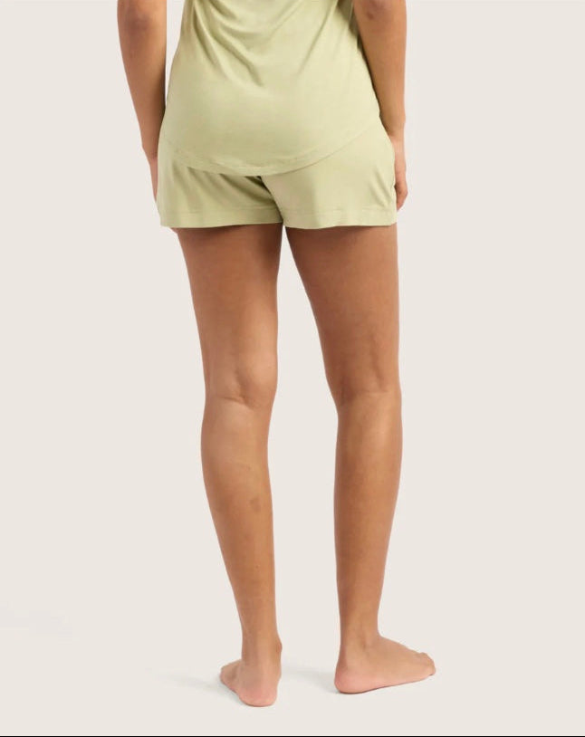 Person wearing light green shorts on a plain background