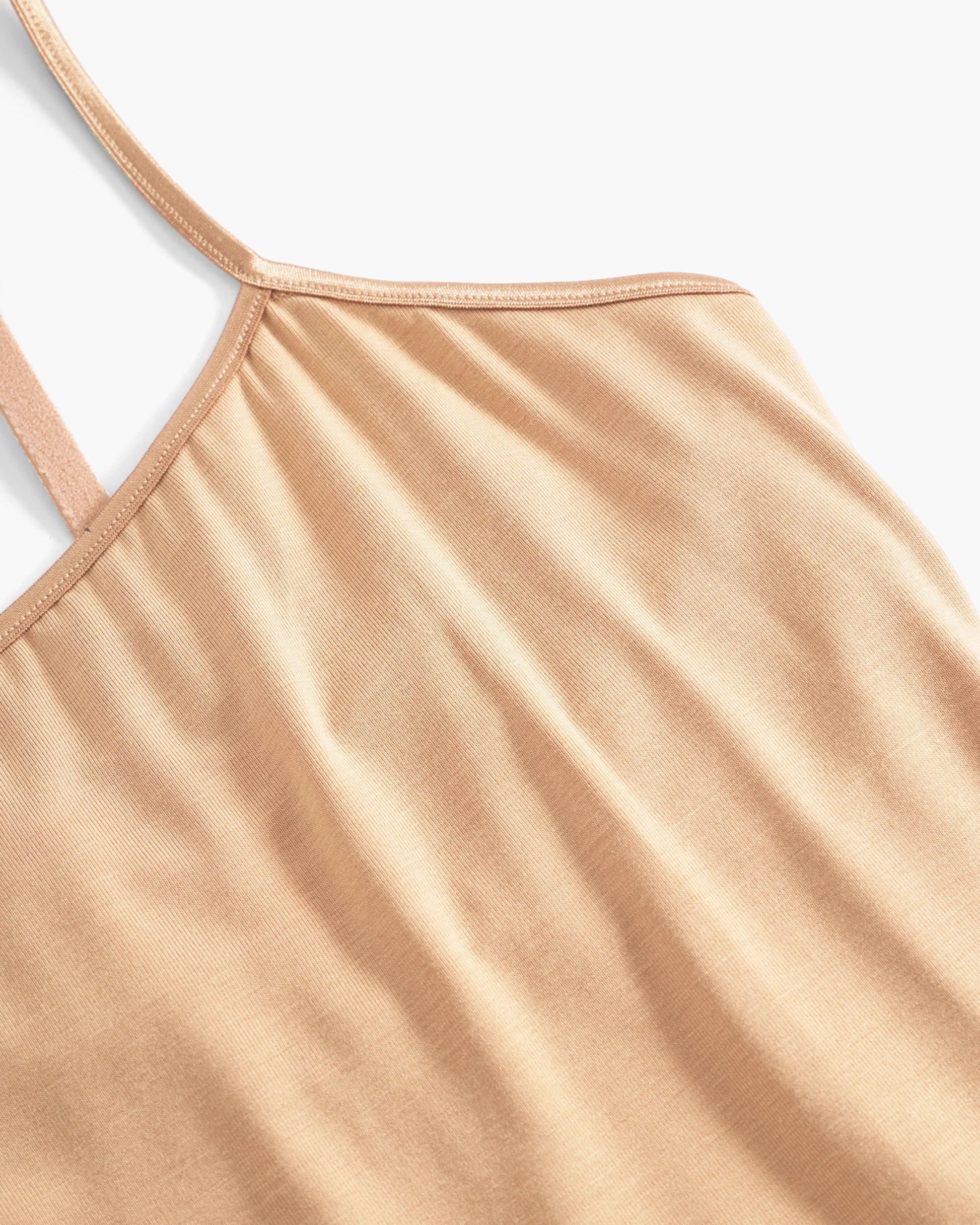 Close-up of a beige tank top with thin straps on a light gray background