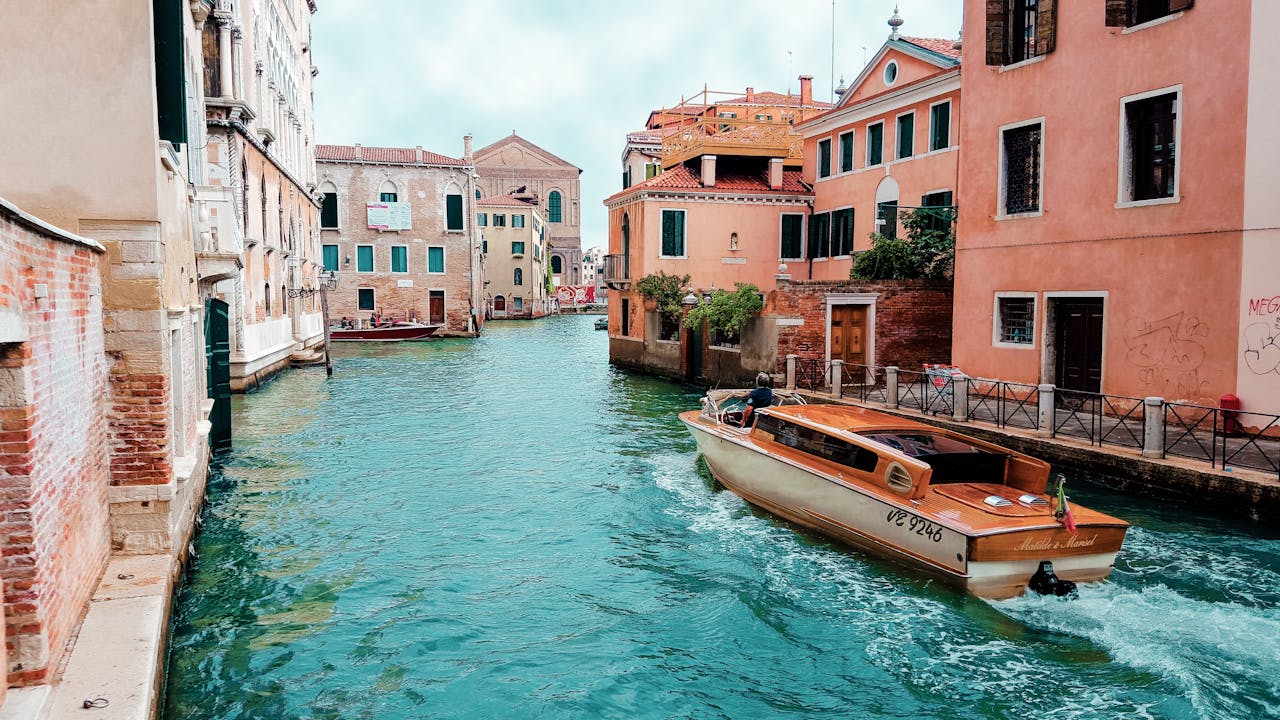 Venetian canal with a boat and colorful buildings in Venice, Italy