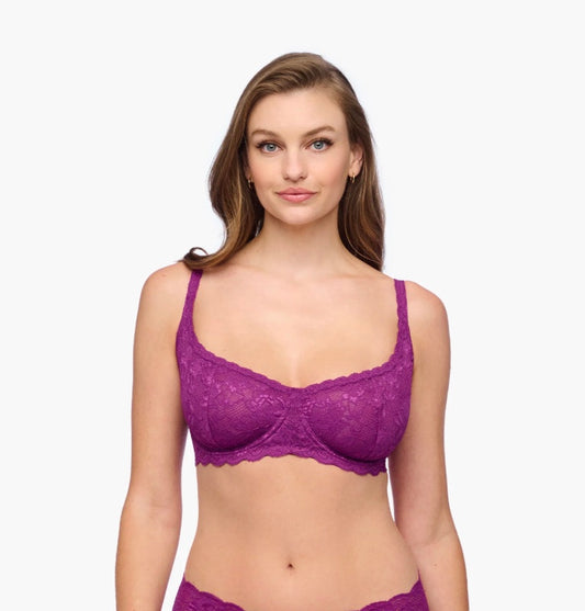 Woman wearing a purple bra and panties set on a white background
