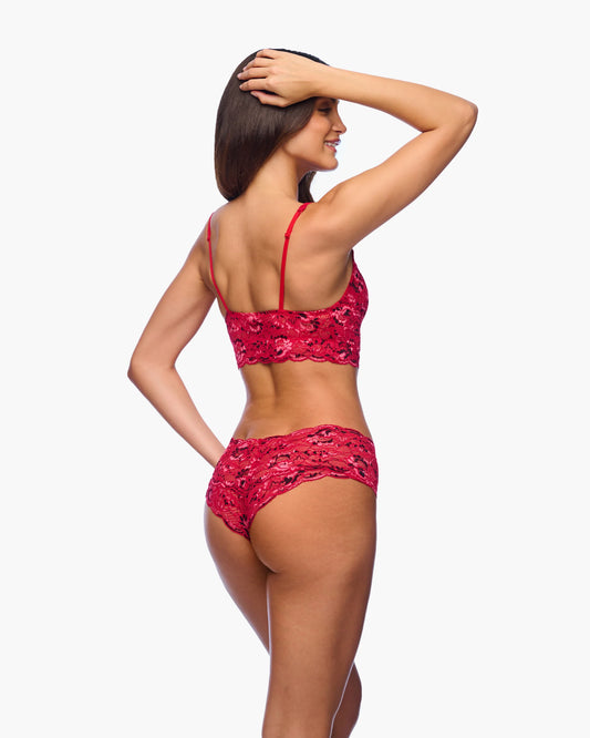 Woman wearing a red lace lingerie set on a white background