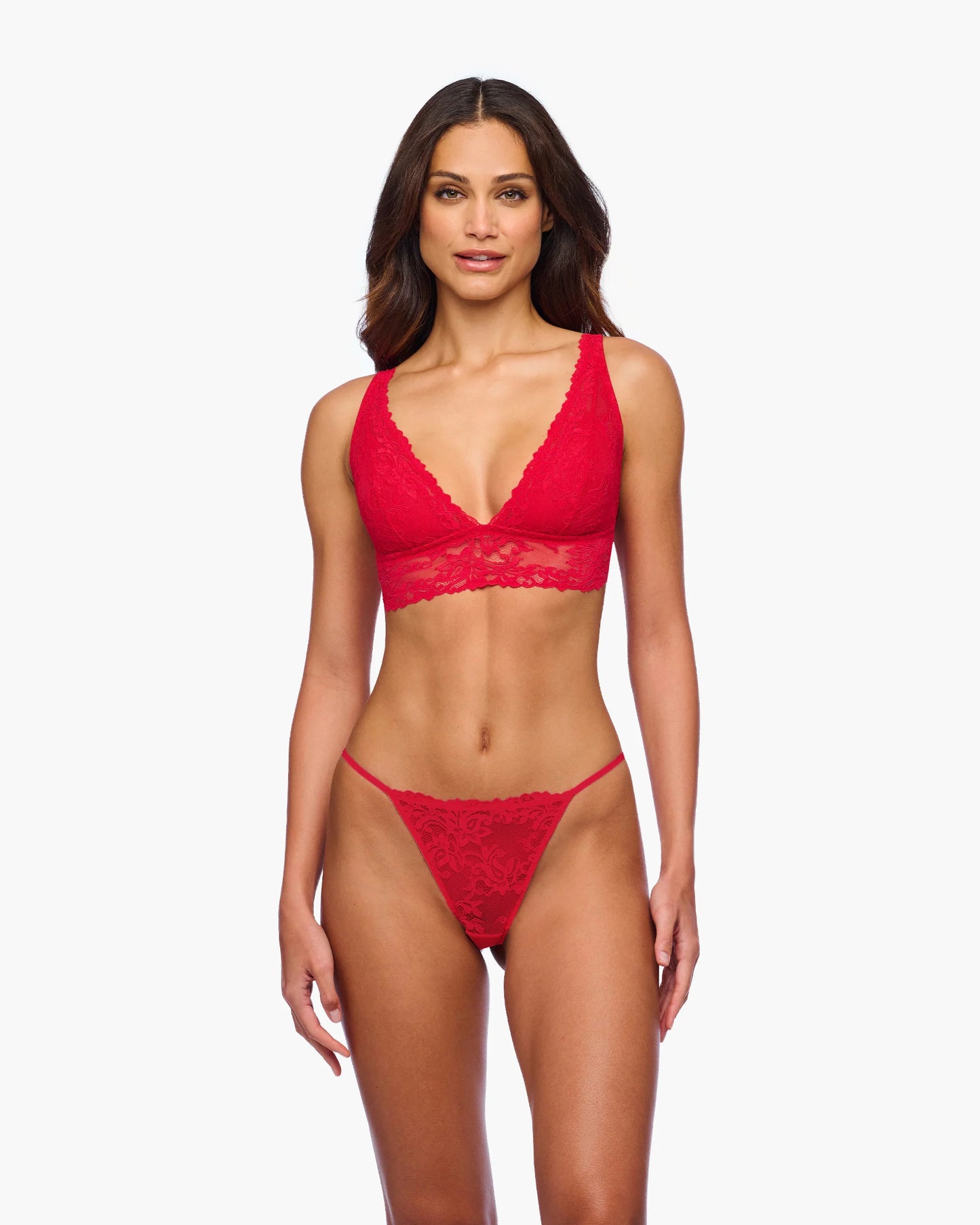 Woman wearing a red lace lingerie set on a white background