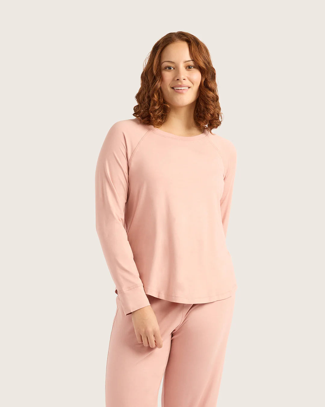 Woman wearing a pink outfit on a plain background