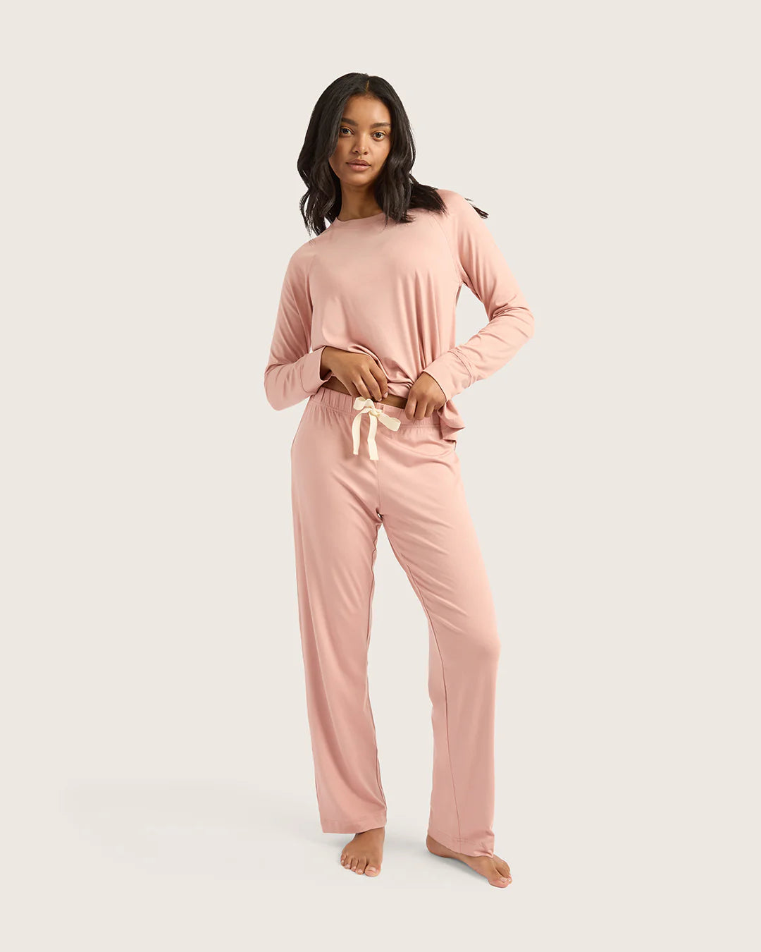 Woman wearing a pink pajama set on a white background