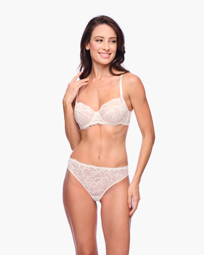 Woman wearing a white lace lingerie set on a white background
