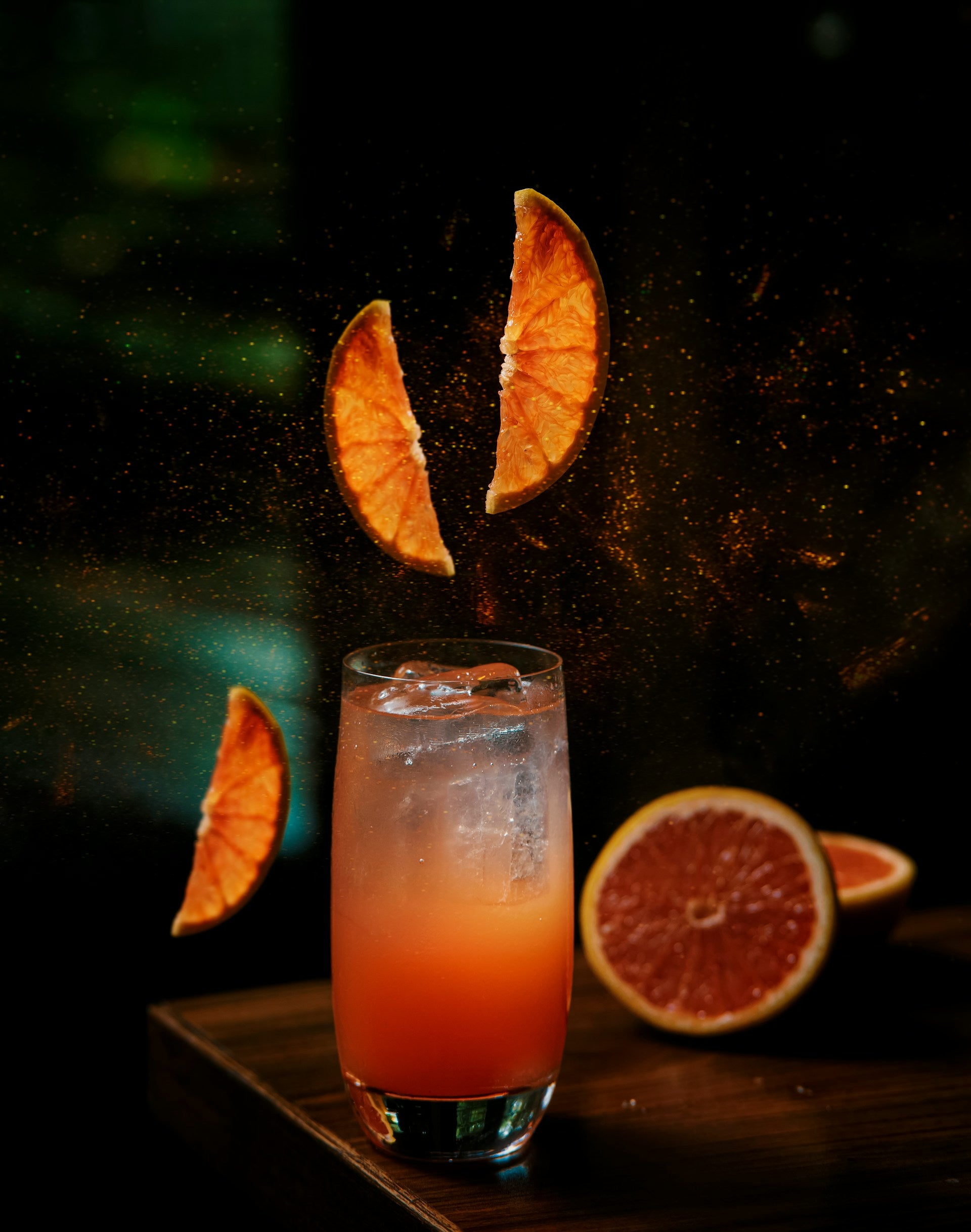 Cocktail with ice and orange slices on a dark background