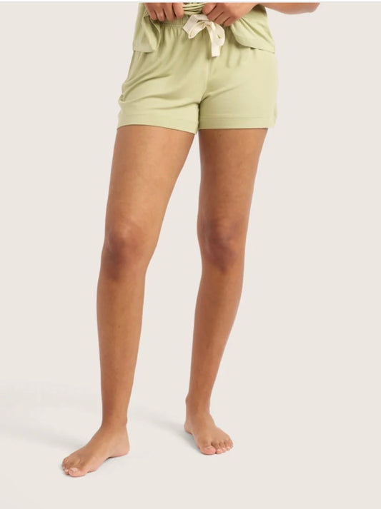 Person wearing light green shorts on a plain background