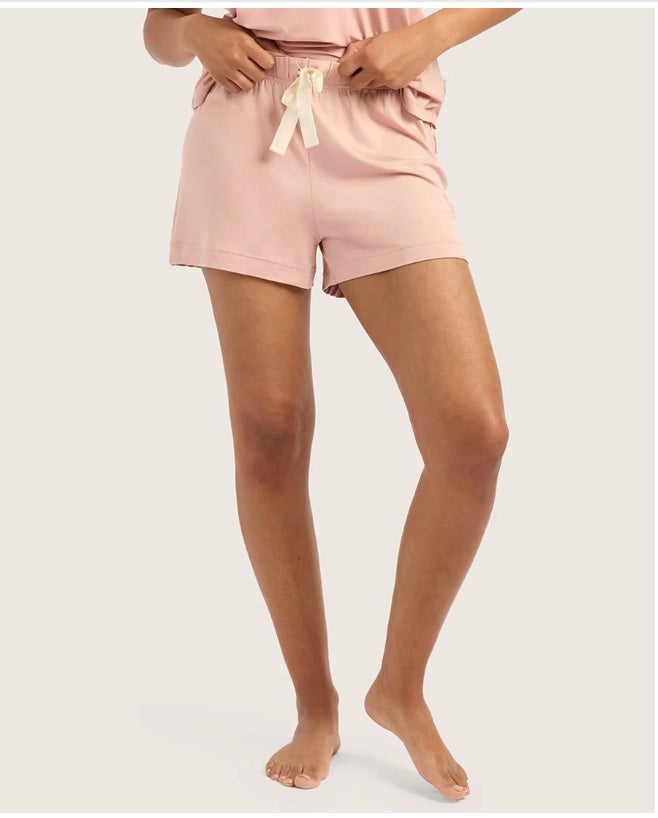 Person wearing pink shorts with a white background