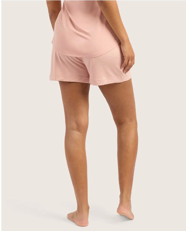 Person wearing pink shorts with a white background